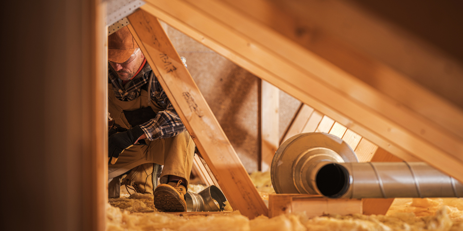 HVAC Tech in attic working on insulation - How to Insulate Your Attic this Winter