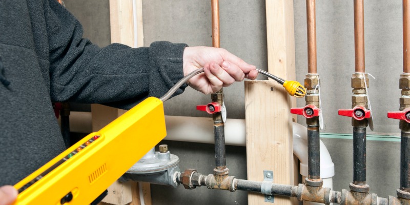 HVAC technician inspecting gas leak in home