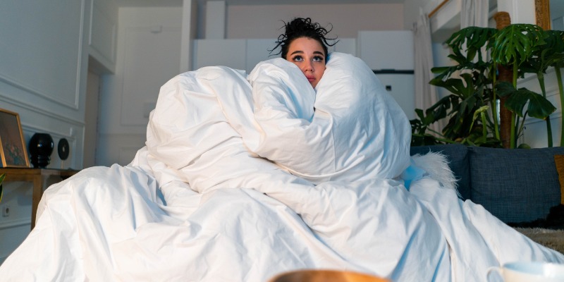 woman bundled up in comforter