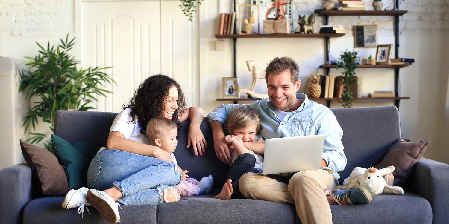 Family at hone on couch looking at computer screen - Answering Air Purifier FAQs: Your Guide to Removing Smells and Toxins