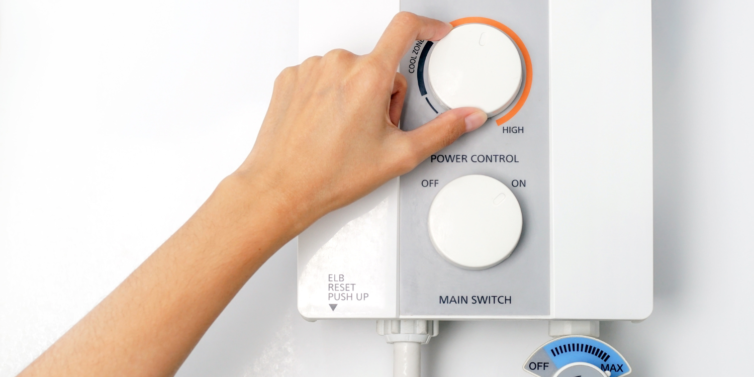 Hand on knob of tankless water heater system - Condensing vs Non-Condensing Tankless Water Heater: What's the Difference?